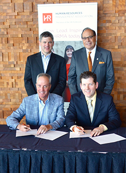 Simon Bachrich program head, HR Management at BCIT School of Business (back left); Anthony Ariganello, president and CEO, HRMA (back right); TJ Schmaltz, chair, HRMA (front right); and Hugh Finlayson, chair of the BCIT HR program industry advisory committee (front left) sign a partnership agreement at HRMA’s Annual Conference + Tradeshow on April 27, 2016.
